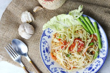 Somtum, Tayland baharatlı papaya salatası beyaz arka planda, uluslararası Tayland yemeği bilinen ve popüler, papaya ve domatesle yapılan, ekşi, tatlı ve baharatlı.