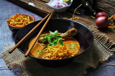 Kuzey Tayland Körili Erişte Tavuklu, Kuzey Tayland Gıda Yüksek Kontrastlı fotoğraf, yemek fotoğrafçılığı, dokulu ahşap masa.