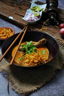 Kuzey Tayland Körili Erişte Tavuklu, Kuzey Tayland Gıda Yüksek Kontrastlı fotoğraf, yemek fotoğrafçılığı, dokulu ahşap masa.