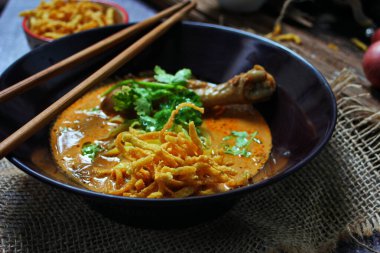 Kuzey Tayland Körili Erişte Tavuklu, Kuzey Tayland Gıda Yüksek Kontrastlı fotoğraf, yemek fotoğrafçılığı, dokulu ahşap masa.