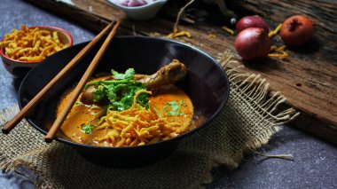 Kuzey Tayland Körili Erişte Tavuklu, Kuzey Tayland Gıda Yüksek Kontrastlı fotoğraf, yemek fotoğrafçılığı, dokulu ahşap masa.