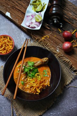 Kuzey Tayland Körili Erişte Tavuklu, Kuzey Tayland Gıda Yüksek Kontrastlı fotoğraf, yemek fotoğrafçılığı, dokulu ahşap masa.