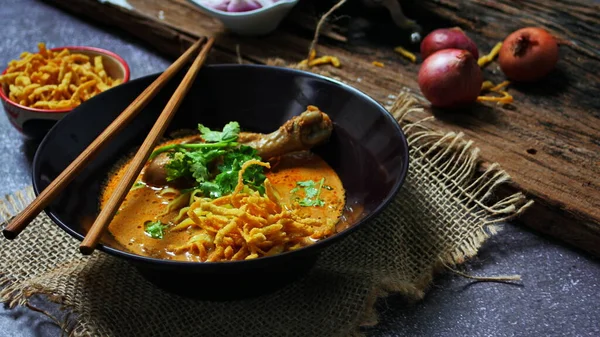 Kuzey Tayland Körili Erişte Tavuklu, Kuzey Tayland Gıda Yüksek Kontrastlı fotoğraf, yemek fotoğrafçılığı, dokulu ahşap masa.