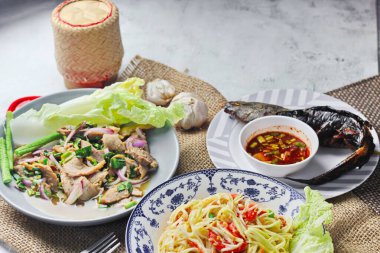 Tayland 'da bir restoranda masada lezzetli Tayland yemekleri, papaya salatası, larb, şelale, yapışkan pirinç..