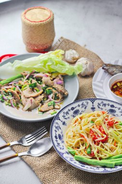 Tayland 'da bir restoranda masada lezzetli Tayland yemekleri, papaya salatası, larb, şelale, yapışkan pirinç..