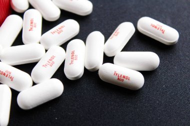 Bangkok, Tayland - 10 Ekim 2023 - Siyah arka plana yerleştirilmiş Tylenol hapları, Tylenol hapları, ağrı kesiciler, ateş hapları, Amerika 'da ağrı kesici