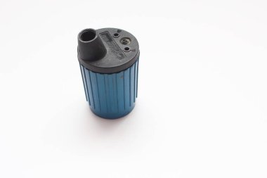 Mavi bir kalemtıraş beyaz arka planda oturuyor..