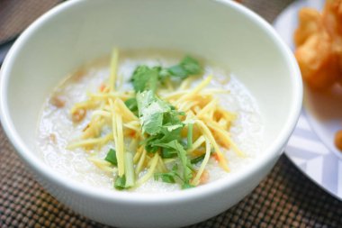Tahta bir masada servis edilen Tayland usulü bir fincanda şaka ya da congee. Asya kahvaltısı..
