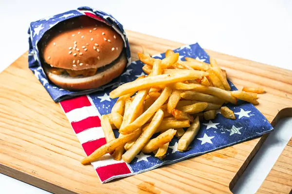 Cheese burger - American cheese burger with Golden French fries on wooden board
