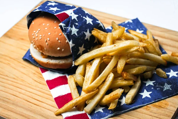 Cheese burger - American cheese burger with Golden French fries on wooden board