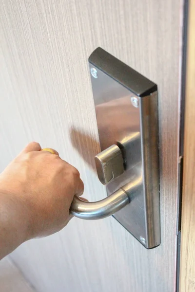 Closeup of woman\'s hand opening the door knob with a key.