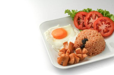 Amerikan usulü kahvaltı seti, kızarmış pilav kızarmış tavuk, sosis ve sebze beyaz tabakta.