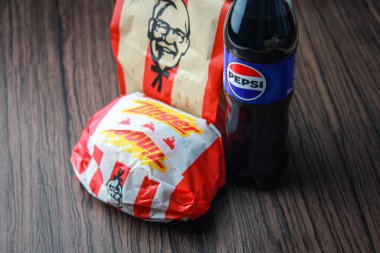 Bangkok, Tayland - 3 Mart 2024 - KFC Tavuk Zinger Burger ve Pepsi Soda ile Taze Kızartma Siyah ahşap bir masa, hazır yiyecek, abur cubur, KFC kızarmış tavuk, Pepsi Yeni logo.