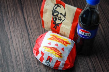 Bangkok, Tayland - 3 Mart 2024 - KFC Tavuk Zinger Burger ve Pepsi Soda ile Taze Kızartma Siyah ahşap bir masa, hazır yiyecek, abur cubur, KFC kızarmış tavuk, Pepsi Yeni logo.