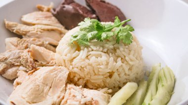 Hainanese chicken rice with soup on dark wooden table background. thaifood concept. clipart