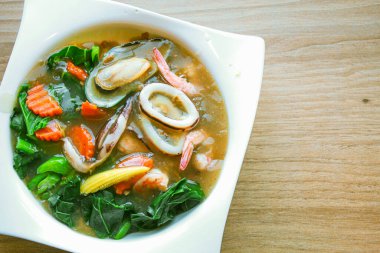 Soslu deniz mahsullü Wide Rice Noodles, ya da bizim Rad-Na Taley dediğimiz gibi, Asya restoranında beyaz bir tabakta servis edilir..