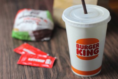 Bangkok, Tayland - 23 Mart 2023 - Burger King seti, Whopper ve meşrubatlar koyu kahverengi ahşap masaya yerleştirildi.
