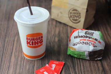 Bangkok, Tayland - 23 Mart 2023 - Burger King seti, Whopper ve meşrubatlar koyu kahverengi ahşap masaya yerleştirildi.