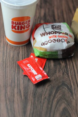Bangkok, Tayland - 23 Mart 2023 - Burger King seti, Whopper ve meşrubatlar koyu kahverengi ahşap masaya yerleştirildi.