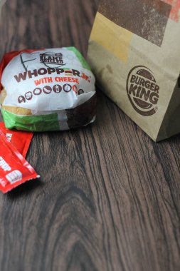 Bangkok, Tayland - 23 Mart 2023 - Burger King seti, Whopper ve meşrubatlar koyu kahverengi ahşap masaya yerleştirildi.