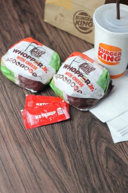 Bangkok, Tayland - 23 Mart 2023 - Burger King seti, Whopper ve meşrubatlar koyu kahverengi ahşap masaya yerleştirildi.