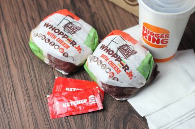 Bangkok, Tayland - 23 Mart 2023 - Burger King seti, Whopper ve meşrubatlar koyu kahverengi ahşap masaya yerleştirildi.