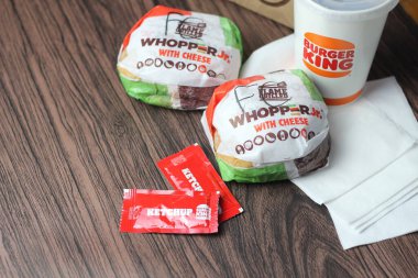Bangkok, Tayland - 23 Mart 2023 - Burger King seti, Whopper ve meşrubatlar koyu kahverengi ahşap masaya yerleştirildi.
