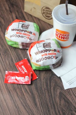 Bangkok, Tayland - 23 Mart 2023 - Burger King seti, Whopper ve meşrubatlar koyu kahverengi ahşap masaya yerleştirildi.