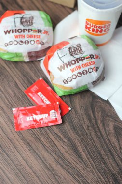 Bangkok, Tayland - 23 Mart 2023 - Burger King seti, Whopper ve meşrubatlar koyu kahverengi ahşap masaya yerleştirildi.