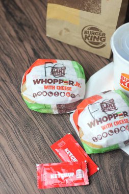 Bangkok, Tayland - 23 Mart 2023 - Burger King seti, Whopper ve meşrubatlar koyu kahverengi ahşap masaya yerleştirildi.