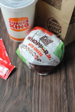 Bangkok, Tayland - 23 Mart 2023 - Burger King seti, Whopper ve meşrubatlar koyu kahverengi ahşap masaya yerleştirildi.