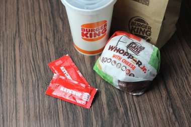 Bangkok, Tayland - 23 Mart 2023 - Burger King seti, Whopper ve meşrubatlar koyu kahverengi ahşap masaya yerleştirildi.