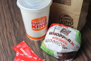 Bangkok, Tayland - 23 Mart 2023 - Burger King seti, Whopper ve meşrubatlar koyu kahverengi ahşap masaya yerleştirildi.