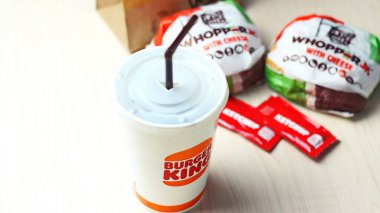 WASHINGTON - ABD - 17 Ağustos 2024 Klasik bir Burger King yemek Whopper Jr. içeceği, ketçap paketleri ve kahverengi bir kese kağıdının detayları.