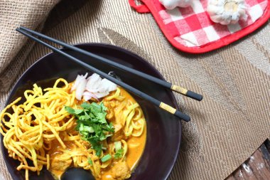 Altın yumurtalı erişte ve canlı yeşil süslemeler bu ağız sulandıran Khao Soi 'deki zengin, kremalı köri' ye karşı güzel bir tezat oluşturuyor..