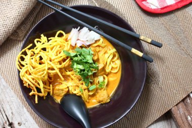 Altın yumurtalı erişte ve canlı yeşil süslemeler bu ağız sulandıran Khao Soi 'deki zengin, kremalı köri' ye karşı güzel bir tezat oluşturuyor..