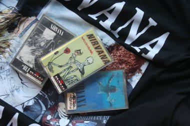 Resimde siyah Nirvana tişörtüne yerleştirilmiş üç Nirvana kaseti - 