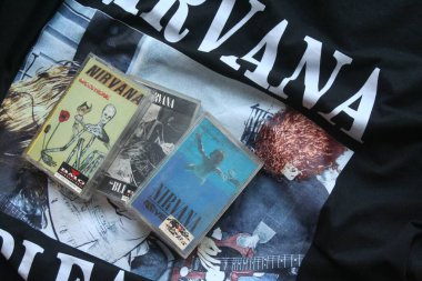 Resimde siyah Nirvana tişörtüne yerleştirilmiş üç Nirvana kaseti - 