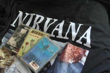 Resimde siyah Nirvana tişörtüne yerleştirilmiş üç Nirvana kaseti - 