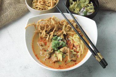 Khao Soi Moo Tayland 'da ve yurt dışında popüler olan bir Kuzey Tayland yemeğidir. Erişte, hindistan cevizi sütlü köri, arpacık soğanı ve Çin lahanasından oluşuyor..