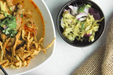 Hint cevizi sütlü erişte, Khao Soi Moo dediğimiz Tayland yemeği, soğan, domuz eti, turşu ve hindistan cevizi sütü içeriyor..