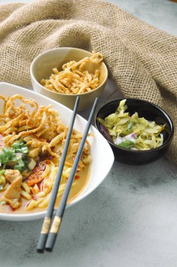 Hint cevizi sütlü erişte, Khao Soi Moo dediğimiz Tayland yemeği, soğan, domuz eti, turşu ve hindistan cevizi sütü içeriyor..