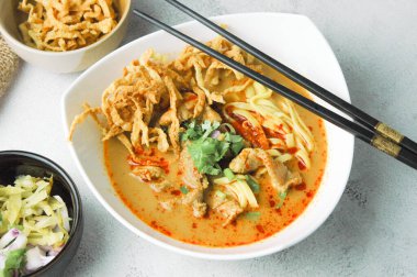 Khao Soi Moo, Tayland yemeği, Kuzey Tayland yemeği, Tayland yemeği, malzeme olarak erişte ve hindistan cevizi sütü, arpacık soğanı, sebze turşusu..