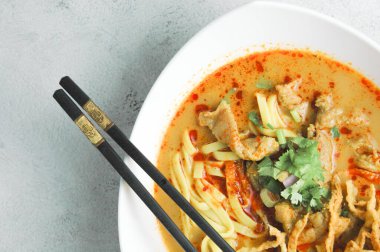 Hint cevizi sütlü erişte, Khao Soi Moo dediğimiz Tayland yemeği, soğan, domuz eti, turşu ve hindistan cevizi sütü içeriyor..