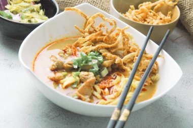 Hint cevizi sütlü erişte, Khao Soi Moo dediğimiz Tayland yemeği, soğan, domuz eti, turşu ve hindistan cevizi sütü içeriyor..