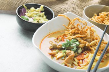 Hint cevizi sütlü erişte, Khao Soi Moo dediğimiz Tayland yemeği, soğan, domuz eti, turşu ve hindistan cevizi sütü içeriyor..