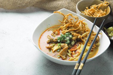 Hint cevizi sütlü erişte, Khao Soi Moo dediğimiz Tayland yemeği, soğan, domuz eti, turşu ve hindistan cevizi sütü içeriyor..