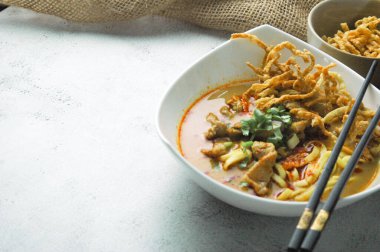 Hint cevizi sütlü erişte, Khao Soi Moo dediğimiz Tayland yemeği, soğan, domuz eti, turşu ve hindistan cevizi sütü içeriyor..