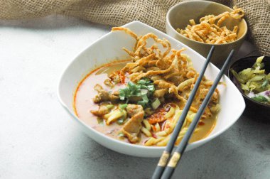 Hint cevizi sütlü erişte, Khao Soi Moo dediğimiz Tayland yemeği, soğan, domuz eti, turşu ve hindistan cevizi sütü içeriyor..