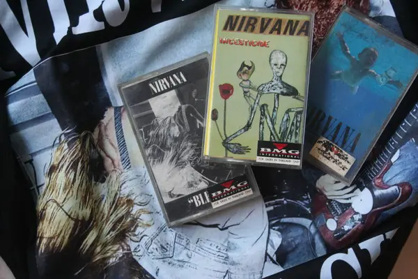 Resimde siyah Nirvana tişörtüne yerleştirilmiş üç Nirvana kaseti - 